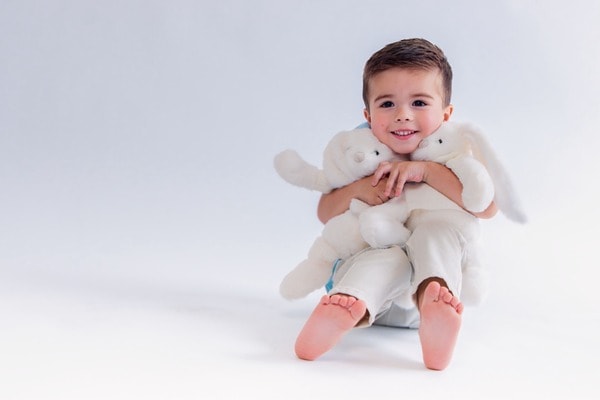 Nino abrazando peluches en blanco